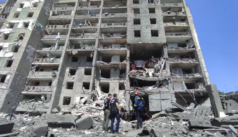 epaselect epa10045304 Prosecutor workers and rescuers stand at the scene of a damaged residential building after shelling hit the small town of Serhiivka near Odesa, southern Ukraine, 01 July 2022. At least 19 people were killed and 38 others injured, including six children, after overnight shelling hit a nine-story building and two holiday hotels in Serhiivka, Bilhorod-Dnistrovskyi district, Odesa region, the state emergency service said in a statement on 01 July. EPA/STRINGER