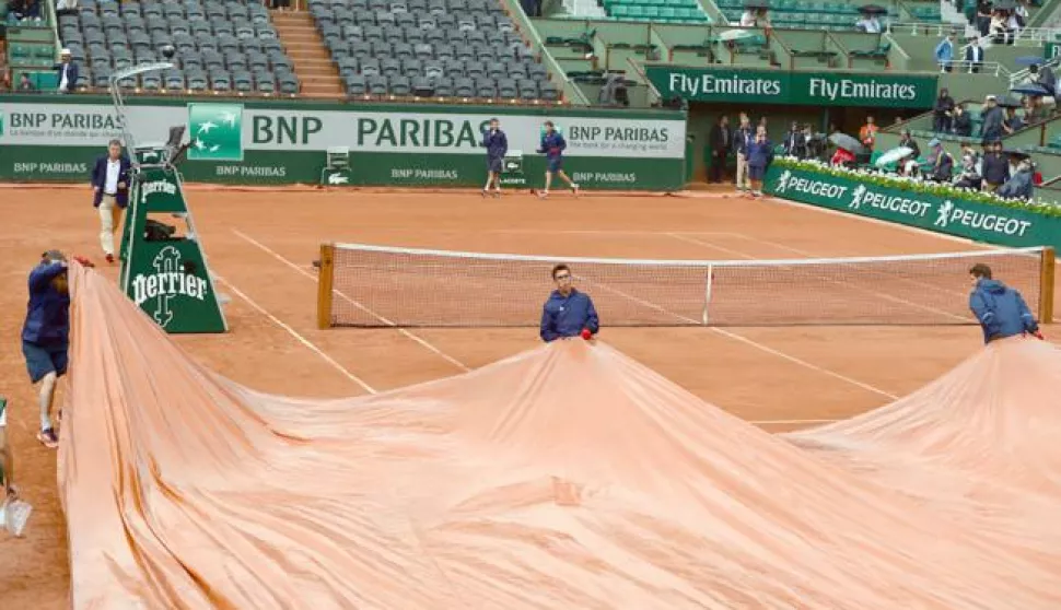 epa06789249 The court is covered as Rafael Nadal of Spain playing Diego Schwartzman of Argentina during their men’s quarter final match is interrupted due to rain during the French Open tennis tournament at Roland Garros in Paris, France, 06 June 2018. EPA/CAROLINE BLUMBERG------2x color - sport