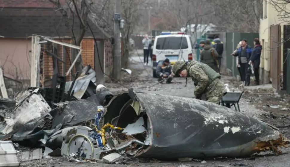 epa09783630 A soldier looks at the debris of a military plane that was shot down overnight in Kiev, Ukraine, 25 February 2022. Russian troops entered Ukraine on 24 February prompting the country's president to declare martial law. EPA/SERGEY DOLZHENKO