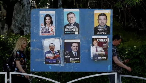 epa12069545 People pass by a billboard displaying electoral posters of candidates for the 2025 presidential elections, in Bucharest, Romania, 02 May 2025. Romanians will vote in the first round of the presidential elections on 04 May 2025. EPA/ROBERT GHEMENT