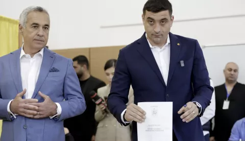 epa12072388 Presidential candidate and far-right party Alliance for the Union of Romanians (AUR) leader George Simion (R) and banned candidate Calin Georgescu cast their ballots in the first round of presidential elections at a polling station in Secondary School No. 08 in Mogosoaia village, near Bucharest, Romania, 04 May 2025. Romanian voters are returning to the polls this weekend for a repeat of the first round of the presidential election, originally held on 24 November 2024 and later annulled, with around 18 million citizens eligible to vote, according to the Permanent Electoral Authority (AEP). EPA/ROBERT GHEMENT