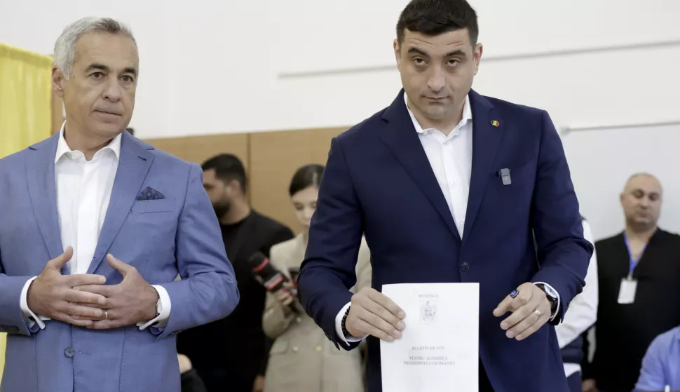 epa12072388 Presidential candidate and far-right party Alliance for the Union of Romanians (AUR) leader George Simion (R) and banned candidate Calin Georgescu cast their ballots in the first round of presidential elections at a polling station in Secondary School No. 08 in Mogosoaia village, near Bucharest, Romania, 04 May 2025. Romanian voters are returning to the polls this weekend for a repeat of the first round of the presidential election, originally held on 24 November 2024 and later annulled, with around 18 million citizens eligible to vote, according to the Permanent Electoral Authority (AEP). EPA/ROBERT GHEMENT