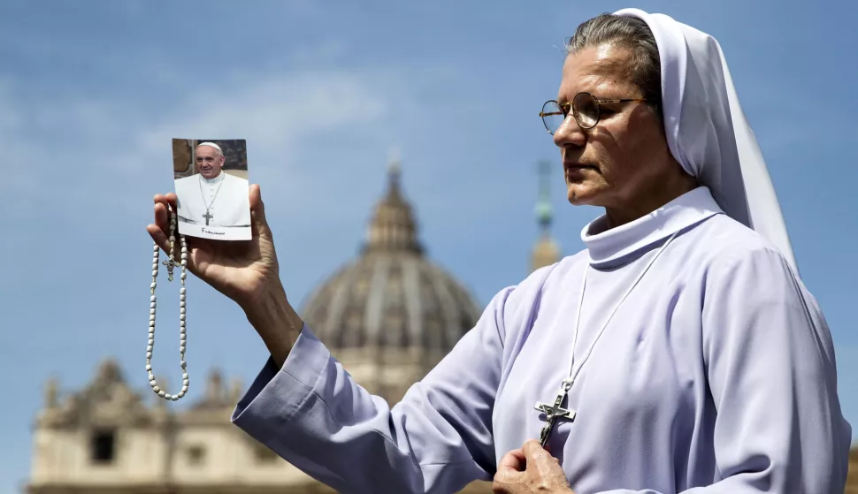 epa12044119 A nun carries a cross and a picture of Pope Francis as she prays in St. Peter's Square following the death of Pope Francis, Vatican City, 21 April 2025. Pope Francis died on 21 April 2025 at the age of 88, according to the Holy See. Born Jorge Mario Bergoglio in Buenos Aires, Argentina, on 17 December 1936, he was appointed leader of the Catholic Church on 13 March 2013, succeeding Pontiff Emeritus Benedict XVI. EPA/ANGELO CARCONI