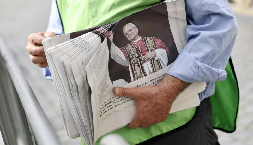 epa12085661 A volunteer distributes copies of the Vatican City daily newspaper 'L'Osservatore Romano' in St. Peter's Square, Vatican, 09 May 2025, the day after Cardinal Robert Prevost's election as Pope Leo XIV. EPA/ANDREA SOLERO