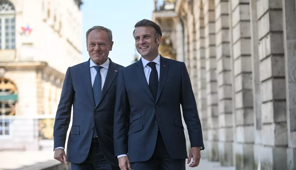 epa12086753 French President Emmanuel Macron (R) and Polish Prime Minister Donald Tusk (L) talk on Stanislas Square in Nancy, France, 09 May 2025. French President Macron and Polish Prime Minister Tusk met in Nancy as part of a summit to sign the French-Polish Strategic Pact, a treaty of friendship and enhanced cooperation between France and Poland. EPA/MARCIN OBARA POLAND OUT