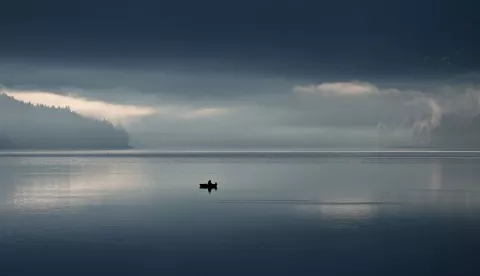 epa12061758 A fisherman in their boat at the lake Walchensee, which has very low water level at this time, in Kochel, Bavaria, Germany, 29 April 2025. EPA/ANNA SZILAGYI