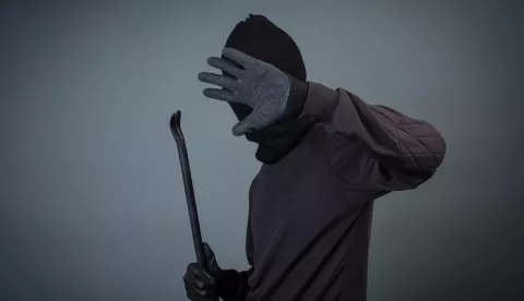 Black criminals wore a head yarn on a gray background.  imali su pajser, i dva ključa s kojima su nasilno otvarali zaključana vrata. Na glavu su stavili kapuljaču, a na ruke građevinske rukavice. lopov provalnik pajser krađa kriminal ilustracijafreepik