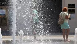 Osijek, 12. 07. 2024, Trg Ante Starcevica, fontana, turisti se osvjezavaju u fontani. Oko 14 sati temperatura u Osijeku je bila 38,8 C tako je pokazivao led displej na obali Drave u Zimskoj luci. Ljudi se snalaze na razne nacine kako bi se zastitili od vrucine i sunca. snimio GOJKO MITIĆ