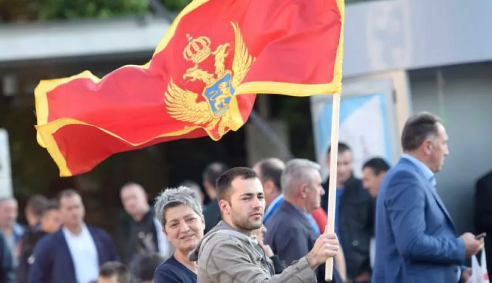 epa05321914 A man holds the Montenegrin flag at the Independence Square during the celebrations for the country's 10th anniversary of its Independence Day in Podgorica, Montenegro, 21 May 2016. EPA/BORIS PEJOVIC
