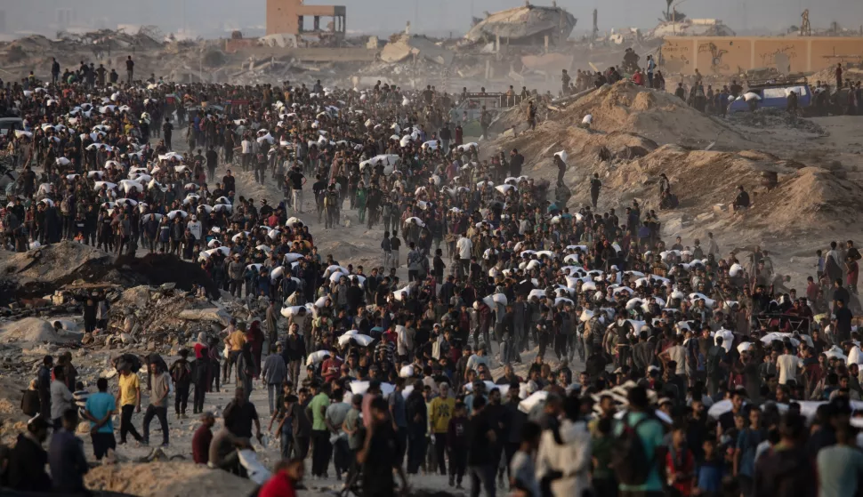 epa12181931 Displaced Palestinians carry bags of flour along Rashid Street in western Jabalia, 17 June 2025, after humanitarian aid trucks entered the northern Gaza Strip through the Israeli-controlled Zikim crossing, northwest of Gaza City. EPA/HAITHAM IMAD