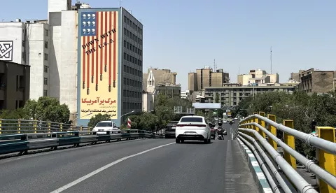 epa12190496 Traffic passes by a building displaying an anti-US mural in Tehran, Iran, 22 June 2025. The US forces struck three of Iran's key nuclear sites: Natanz, Isfahan and Fordo, US President Trump announced on 21 June. Israel and Iran have been exchanging fire since Israel launched strikes across Iran on 13 June 2025 as part of Operation 'Rising Lion.' EPA/ABEDIN TAHERKENAREH