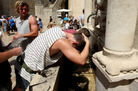 04.08.2017., Dubrovnik - Toplinski val koji je zahvatio Hrvatsku traje i dalje, velike vrucine, sparina te temperatura zraka od 35 stupnjeva stvara probleme u svakodnevnom zivotu. Turisti i dubrovcani pokusavaju se rashladiti na fontani. Photo: Zeljko Lukunic/PIXSELL------GN DVA STUPCA COLOR SPORT