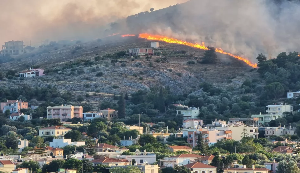 epa12191539 Thick smoke rises as a wildfire burns forested land next to residential areas on Chios Island, Greece, 22 June 2025. A fire that broke out over the main town of Chios island and is now out of control has led to messages for evacuation of several towns through the 112 emergency number service on 22 June. EPA/KOSTAS KOURGIAS