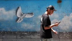 epa12194140 An Iranian man walks past a painting of a dove in a street in Tehran, Iran, 24 June 2025. Israel's military on 24 June, accused Iran of violating a ceasefire, announced earlier by the US president, by launching missiles into Israeli airspace. Israel has been conducting a campaign across Iran since 13 June, targeting nuclear, military, and energy facilities, prompting Iran to launch retaliatory waves of missiles and drones toward Israel. EPA/ABEDIN TAHERKENAREH