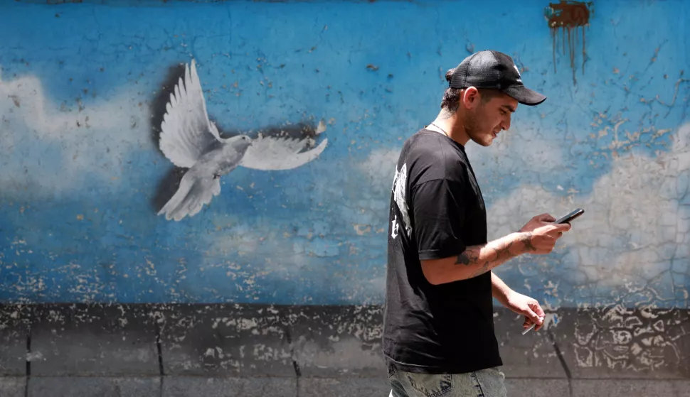 epa12194140 An Iranian man walks past a painting of a dove in a street in Tehran, Iran, 24 June 2025. Israel's military on 24 June, accused Iran of violating a ceasefire, announced earlier by the US president, by launching missiles into Israeli airspace. Israel has been conducting a campaign across Iran since 13 June, targeting nuclear, military, and energy facilities, prompting Iran to launch retaliatory waves of missiles and drones toward Israel. EPA/ABEDIN TAHERKENAREH