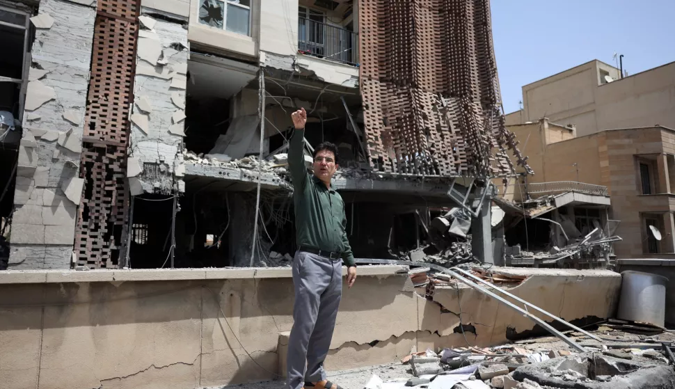 epa12196356 An Iranian man gestures while standing on the roof of his damaged building caused by a recent Israeli airstrike, in Tehran, Iran, 25 June 2025, during a US-mediated ceasefire between Iran and Israel that started on 24 June. Israel has been conducting a campaign across Iran since 13 June, targeting nuclear, military, and energy facilities, prompting Iran to launch retaliatory waves of missiles and drones toward Israel. EPA/ABEDIN TAHERKENAREH