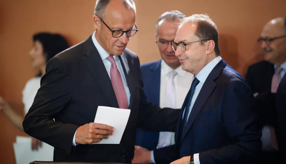 epa12209664 German Chancellor Friedrich Merz (L) passes by German Interior Minister Alexander Dobrindt during a meeting of the German government's cabinet in Berlin, Germany, 02 July 2025. EPA/CLEMENS BILAN