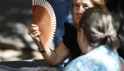 epa12183101 A woman uses a fan to cool down as high temperatures affect the Spanish capital Madrid, Spain, 18 June 2025. EPA/Mariscal
