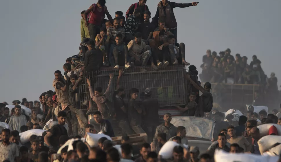 epa12181929 Displaced Palestinians carry bags of flour along Rashid Street in western Jabalia, 17 June 2025, after humanitarian aid trucks entered the northern Gaza Strip through the Israeli-controlled Zikim crossing, northwest of Gaza City. EPA/HAITHAM IMAD