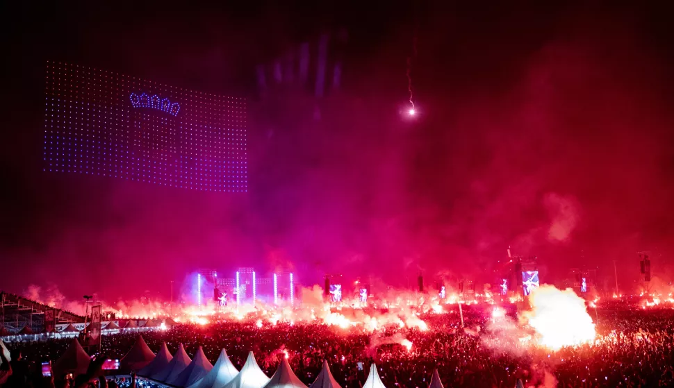 Zagreb, 05.07.2025 - Koncert Marka Perkovića Thompsona na zagrebačkom Hipodromu. Na slici hrvatska zastava napravljena stotinama dronova u zraku iznad hipodroma i bakljada u publici.foto HINA/ Damir SENČAR/ ds