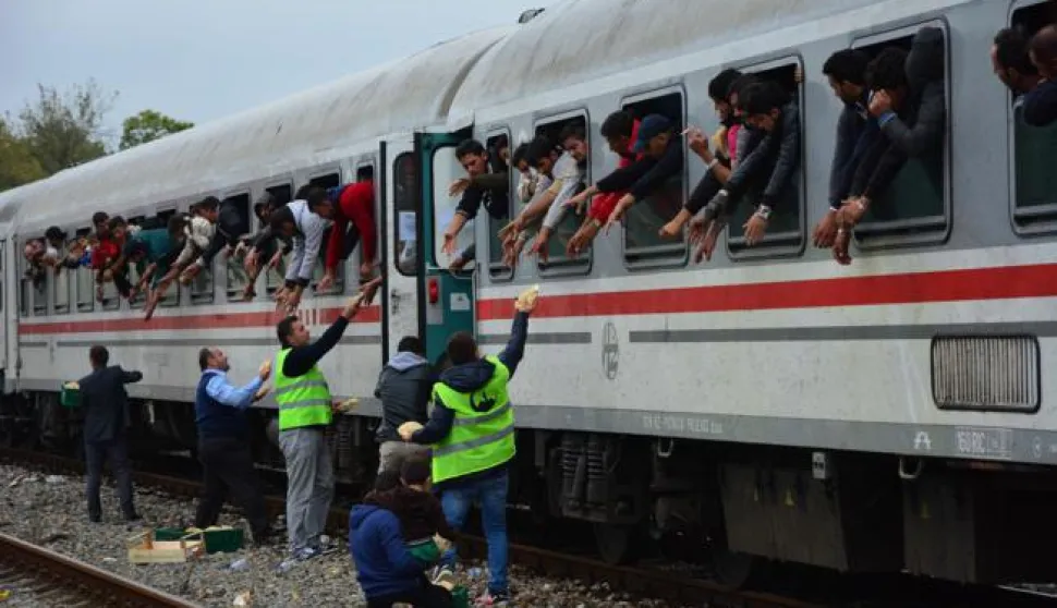 26.09.2015., Spacva - Vlak koji je od jutros stajao na robnom terminalu u Spacvi i do kojeg su izbjeglice iz Strosinaca prevozene autobusom krenuo je za Madjarsku krcat izbjeglicama nesto poslije 16 sati. Humanitarne organizacije i Crveni kriz ponudili su izbjeglicama voce i okrijepu, deke, toplu odjecu i obucu. Photo: Ivica Galovic/ PIXSELL------TRI STUPCA NOVOSTI