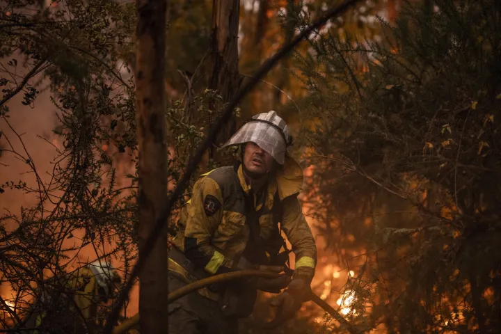 epa12287455 A firefighter works to extinguish an active forest fire in Pontevedra, Spain, 06 August 2025. EPA/Brais Lorenzo