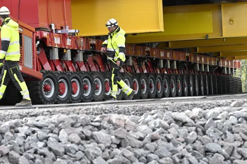epa12309681 Workers check as the Kiruna Church landmark is being moved on a specially designed trolley with 224 wheels at a speed of half a kilometer per hour in Kiruna, northern Sweden, 19 August 2025. The 40-meter-wide, 672,000-kilo wooden church has been placed on a wheeled trailer for its five-kilometre relocation to Kiruna's new town center on 19 and 20 August, due to the expansion of the iron ore mine. EPA/Fredrik Sandberg SWEDEN OUT