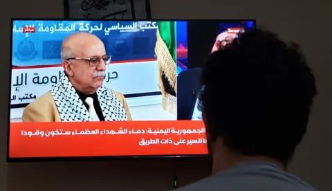 epa12336963 A man watches a TV showing Houthi Prime Minister Ahmed Al-Rahawi, in Sana'a, Yemen, 30 August 2025. Ahmed Al-Rahawi was killed following Israeli airstrikes in the capital on 28 August, Yemen's Houthis confirmed. EPA/YAHYA ARHAB