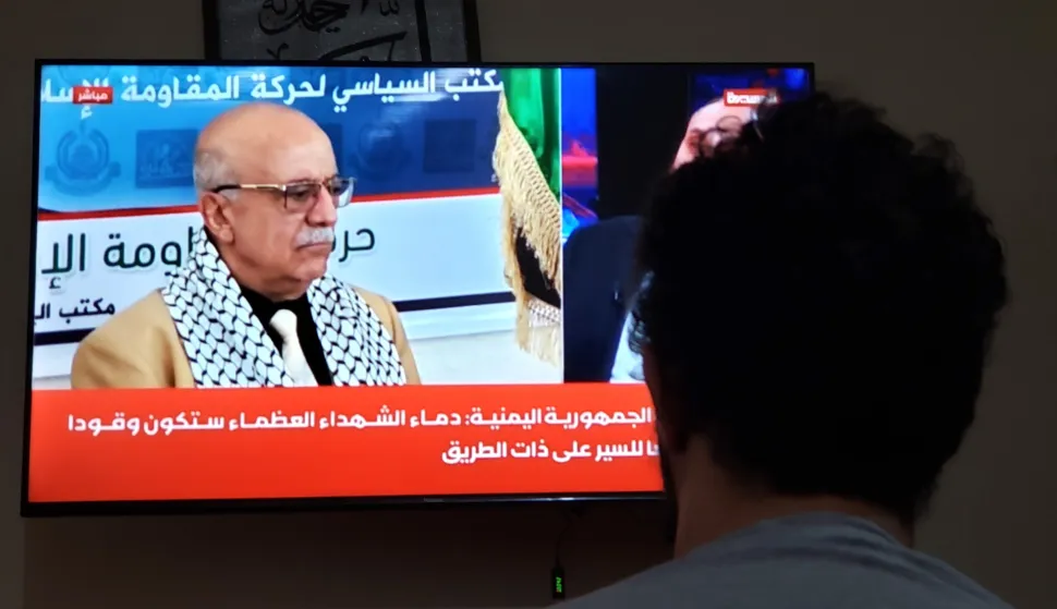 epa12336963 A man watches a TV showing Houthi Prime Minister Ahmed Al-Rahawi, in Sana'a, Yemen, 30 August 2025. Ahmed Al-Rahawi was killed following Israeli airstrikes in the capital on 28 August, Yemen's Houthis confirmed. EPA/YAHYA ARHAB