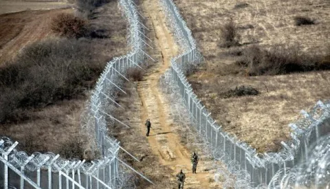 epa05812009 Macedonia soldiers patrol between the razor wire fence at the Macedonian border with Greece, near Gevgelija, The Former Yugoslav Republic of Macedonia, 24 February 2017. Ministers of 15 European countries agreed on 09 February in Vienna, Austria, to prepare new plans and measures that are expected to be presented in April and May to keep the so-called 'Balkan route' - the migration route from Greece to the EU, leading through Macedonia - closed. EPA/GEORGI LICOVSKI