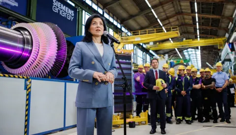 epa12284610 German Economy Minister Katherina Reiche speaks to media in front of a gas turbine (L) and employees during a visit to Siemens Energy in Berlin, Germany, 05 August 2025. EPA/CLEMENS BILAN