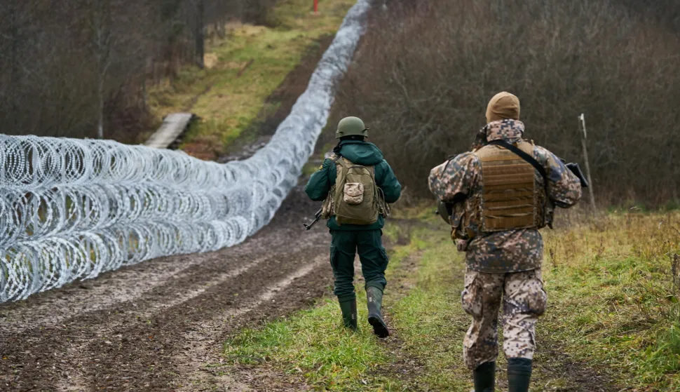 epa09587831 A handout photo made available by Latvian Prime Minister's office shows Latvian Army soldier (R) and Latvian Border guard (L) patrolling along the border during Latvia's Prime Minister Krisjanis Karis (not seen) unannounced visit to Latvian and Belarus border in Silene, Latvia, 17 November 2021. Krisjanis Karins met the border guards and soldiers of the National Armed Forces, who are currently guarding the Latvian-Belarusian border. EPA/LATVIAN PRIME MINISTER OFFICE HANDOUT HANDOUT EDITORIAL USE ONLY/NO SALES