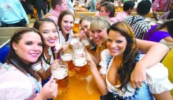 epa05544070 Women pose with full beer mugs in the Hacker festival tent at at the Oktoberfest beer festival in Munich, Germany, 17 September 2016. The 183rd edition of the annual folk and beer festival runs from 17 September to 03 October and is expected to attract once more several millions of visitors from all over the world. EPA/MATTHIAS BALK