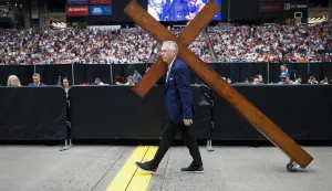 epaselect epa12396242 Dan Beasley carries a wooden cross through State Farm Stadium ahead of the public memorial service of political activist Charlie Kirk in Glendale, Arizona, USA, 21 September 2025. Kirk was shot and killed on 10 September during a stop on his American Comeback Tour organized by Turning Point USA at Utah Valley University. EPA/CAROLINE BREHMAN
