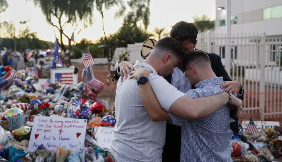 epa12394381 People pray at a makeshift memorial outside of the Turning Point USA headquarters, after conservative political activist Charlie Kirk was killed on 10 September; in Phoenix, Arizona, USA, 20 September 2025. A memorial service for Kirk is scheduled to take place on 21 September in Glendale, Arizona. EPA/CAROLINE BREHMAN
