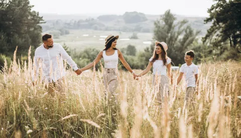 Parents with their children walking in field