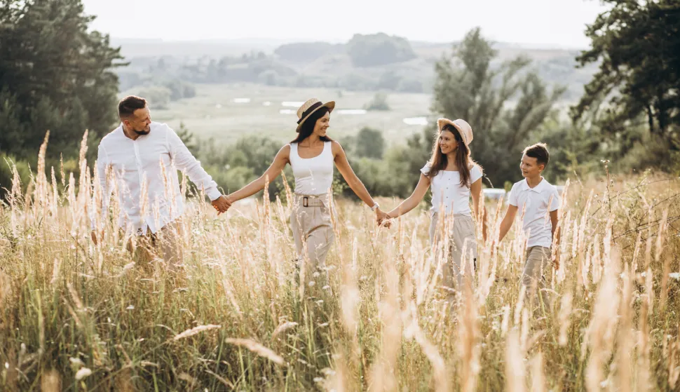 Parents with their children walking in field