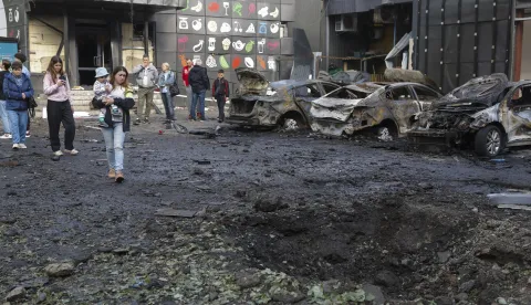 epa12072625 Locals look at a shelling hole at the site of an overnight drone strike that hit a residential area in Kyiv, Ukraine, 04 May 2025, amid the ongoing Russian invasion. At least eleven people were injured, including two children, in the strike on the residential area, according to the State Emergency Service report. Russia launched a large-scale overnight attack using 165 drones across all of Ukraine, according to the Air Force Command of Ukraine. EPA/SERGEY DOLZHENKO