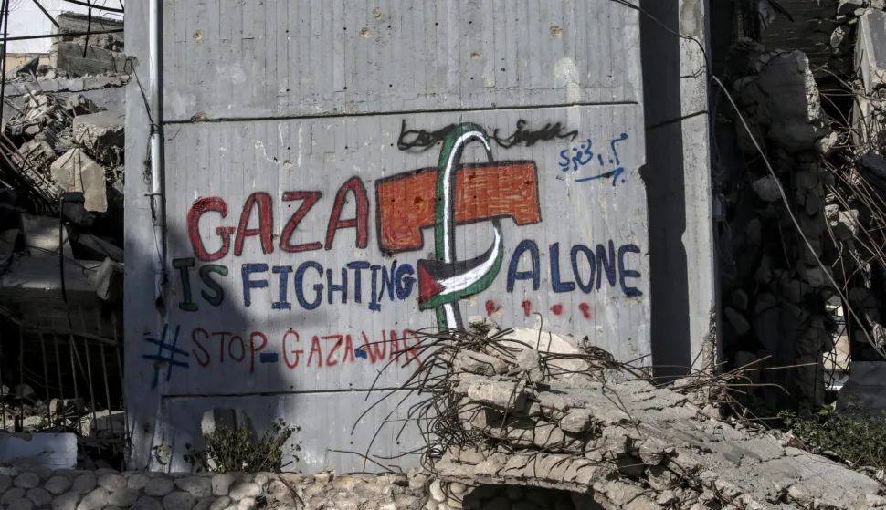 epa12393357 A graffiti on a wall reading 'Gaza is fighting alone' among destroyed buildings in Gaza City, Gaza Strip, 19 September 2025 (issued 20 September 2025). More than 65,200 Palestinians have been killed in the Gaza Strip since October 2023, according to the Palestinian Ministry of Health, and about 1,200 Israelis have been killed since the launch of an Israeli military campaign in response to a cross-border attack by Hamas on 07 October 2023. EPA/MOHAMMED SABER
