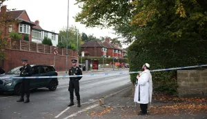 epa12423583 A member of the a Jewish Community holds a Torah at a police cordon in Manchester, Britain, 02 October 2025. Two people have died after a car and stabbing attack at a synagogue in Manchester, with the suspect shot by police. EPA/ADAM VAUGHAN