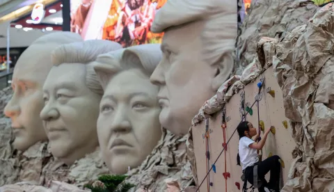 A girl climbs the wall near a caricature of Mount Rushmore, depicting world leaders U.S. President Donald Trump, Chinese President Xi Jingping, North Korean leader Kim Jong Un and Russian President Vladimir Putin, which is on display to promote a fair at a shopping mall, in Bangkok, Thailand, September 25, 2025. REUTERS/Chalinee Thirasupa Photo: CHALINEE THIRASUPA/REUTERS