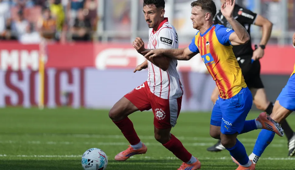 epa12430421 Girona's Ivan Martin (L) vies for the ball against Valencia's Lucas Beltran (R) during a Spanish LaLiga soccer match between Girona FC and Valencia CF in Girona, Catalonia, Spain, 04 October 2025. EPA/David Borrat