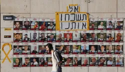 epa12380033 A person walks past pictures of Israeli hostages held by Hamas in Gaza, with a message reading don't forget us, in central Jerusalem, 15 September 2025. According to the Israeli army's spokesperson, some 48 Israeli hostages remain in captivity in the Gaza Strip, including the bodies of at least 30 confirmed dead. EPA/ABIR SULTAN