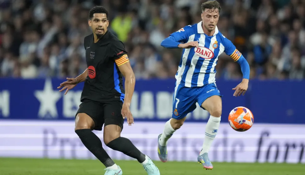 epa12104269 Espanyol´s Javier Puado (R) and Ronald Araujo of FC Barcelona in action during the Spanish LaLiga soccer match between between RCD Espanyol and FC Barcelona, in Cornella de Llobregat, Spain, 15 May 2025. EPA/Enric Fontcuberta