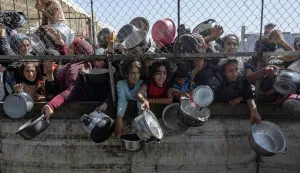 epa12434321 (FILE) - Internally displaced Palestinians gather outside a charity kitchen to receive limited rations amid a shortage of food, in Khan Younis, southern Gaza Strip, 30 May 2025 (reissued 06 October 2025). 07 October 2025 marks two years since the Palestinian militant group Hamas launched a surprise attack on Israel, taking dozens of hostages and killing nearly 1,200 people. In response, Israel began its war on Gaza, which has killed more than 66,000 people, displaced millions and destroyed the Palestinians enclave. EPA/HAITHAM IMAD