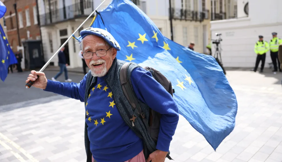 epa12116980 An anti-Brexit protester flies an EU flag outside the Lancaster House on the sidelines of the UK-EU Summit, in London, Britain, 19 May 2025. EPA/NEIL HALL