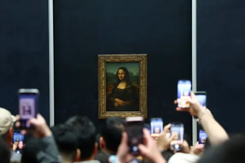Visitors take pictures of the painting "Mona Lisa" (La Joconde) by Leonardo da Vinci at the Louvre Museum on the day it reopened to the public for the first time since last Sunday's heist, while the Galerie d'Apollon where eight pieces of Napoleon and the Empress's jewelry collection displayed in the gallery were stolen by thieves, remains closed, in Paris, France, October 22, 2025. REUTERS/Gonzalo Fuentes Photo: GONZALO FUENTES/REUTERS