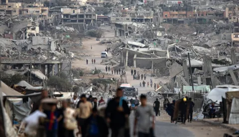 epa12482110 Palestinians walk among the ruins of their destroyed homes in Khan Younis, southern Gaza Strip, 25 October 2025. EPA/HAITHAM IMAD