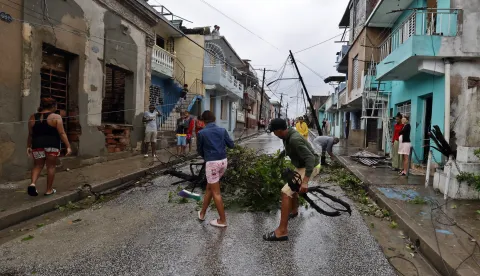 epa12490840 People clear debris on a street affected by Hurricane Melissa in Santiago de Cuba, Cuba, 29 October 2025. Melissa is moving away from Cuba as a Category 2 hurricane, with maximum sustained winds of up to 160 kilometers per hour, and is beginning to head toward the Bahamas after causing flooding, river overflows, and landslides in eastern Cuba. EPA/Ernesto Mastrascusa