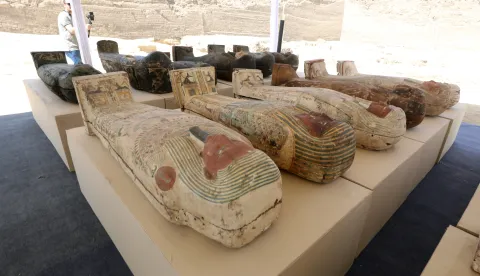 epa09986082 Sarcophaguses are presented to the media near a newly discovered burial site at Saqqara Necropolis in Giza, Egypt, 30 May 2022. A collection of 250 wooden painted coffins with mummies was uncovered during excavations carried out at the Bubastian cemetery at Saqqara Necropolis by an Egyptian archaeological mission led by Mostafa Waziri, the secretary-general of the Supreme Council of Antiquities. Among the finds was also a bronze cachette of 150 bronze statues of ancient Egyptian deities and instruments used for rituals. The collection of different-sized statues depict Bastet, Anubis, Osiris, Amunmeen, Isis, Nefertum and Hathor, and others. The sarcophagi are to be transferred to the Grand Egyptian Museum for display, Waziri said. EPA/KHALED ELFIQI